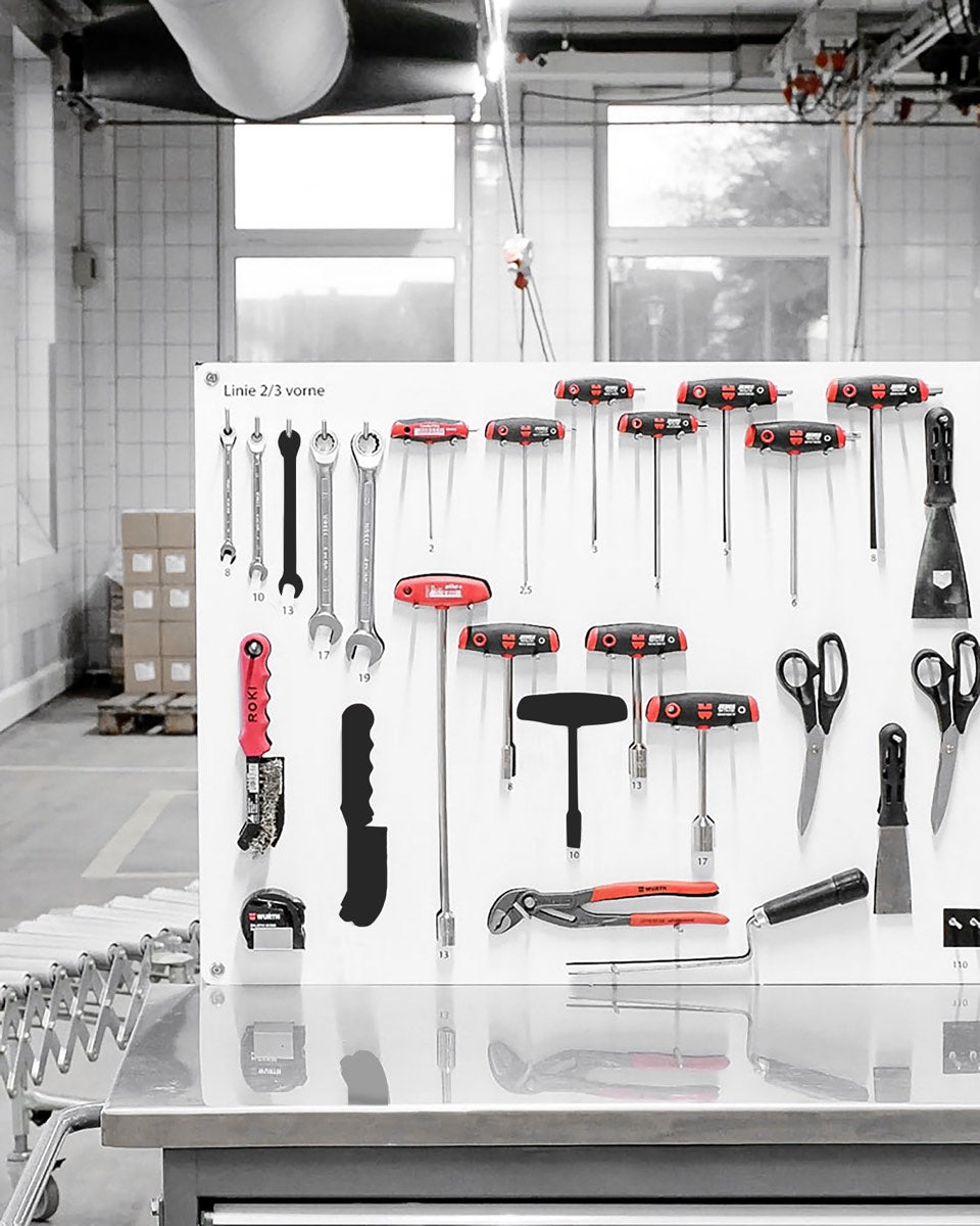 Weiße Schattenwand mit geordneten Handwerkzeugen an einer Produktionslinie